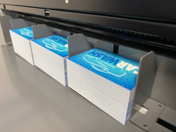 Stacks of finished business cards automatically slit, cut, and creased on a Duplo DC-series slitter/cutter/creaser