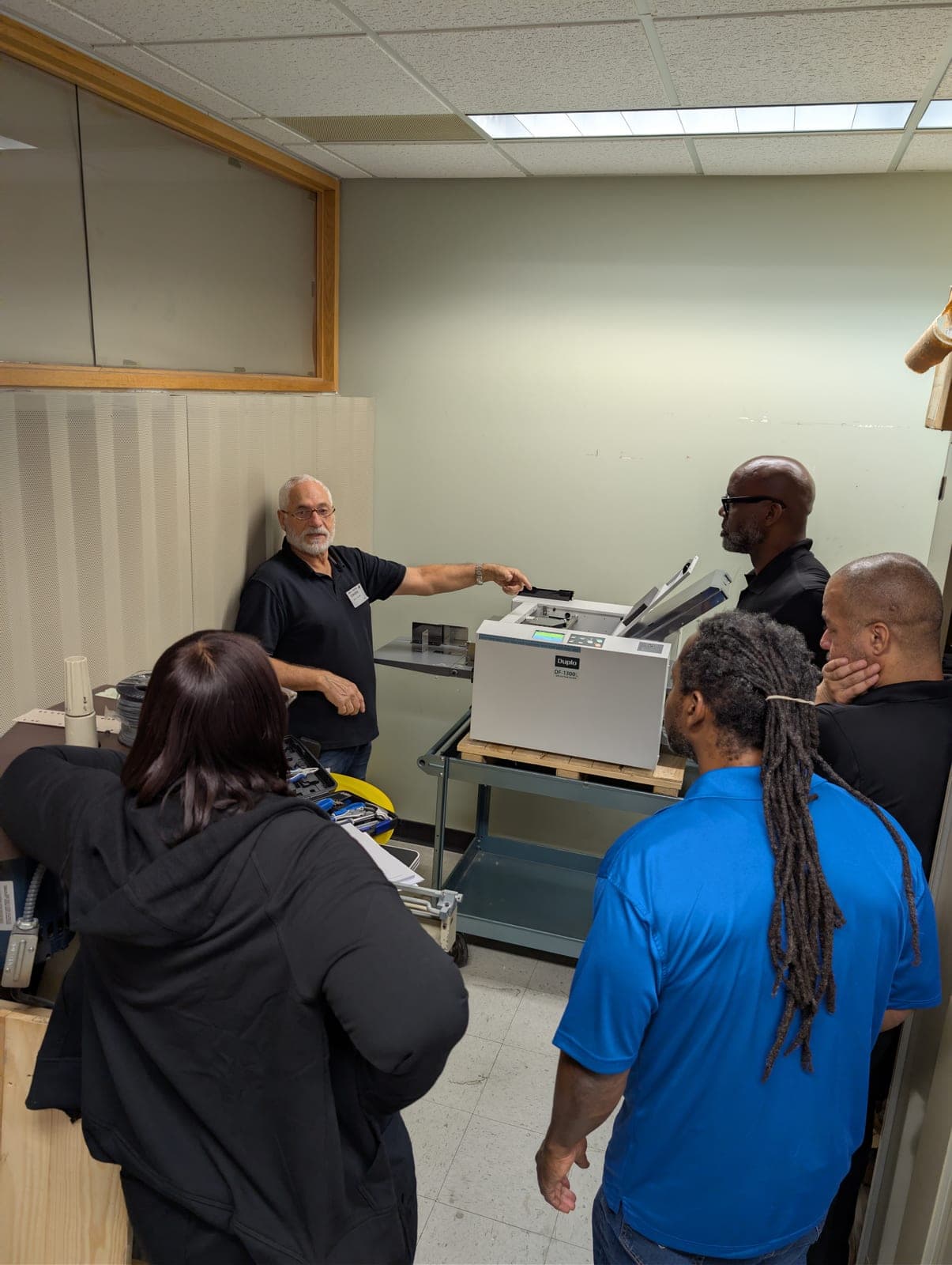 PressTech technician training a customer's team on a Duplo finishing system